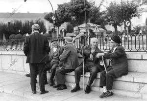 Un grupo de hombres sentados enfrente al Palacio de El Pardo