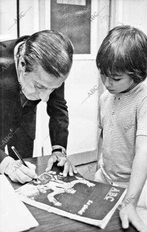 Manolo Vázquez Firmando un autógrafo sobre un ejemplar de Abc