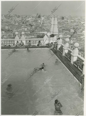 Gente bañándose en la piscina de la terraza del Edificio España