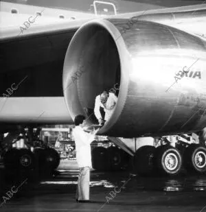 Trabajadores revisando una de los motores de un avión de la Compañía aérea...