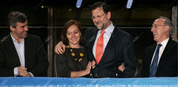 Mariano Rajoy y su equipo saludan desde el balcón de la sede del PP después de...