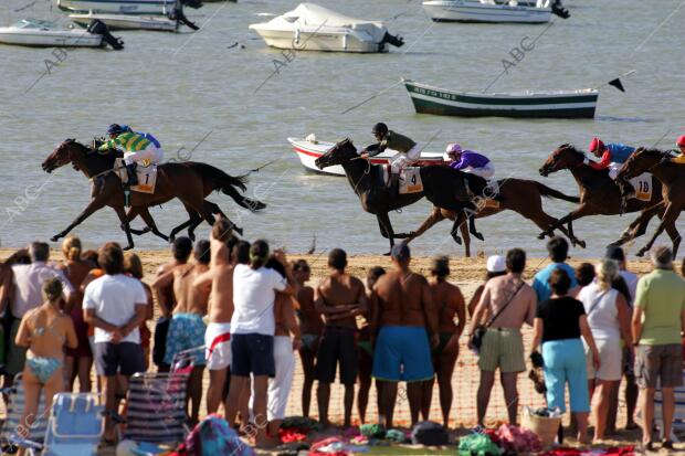 Vista del público asistente a las carreras y los jinetes con sus caballos...