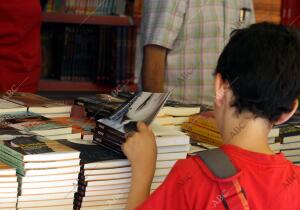 Un niño hojea un ejemplar en la Feria del Libro madrileño