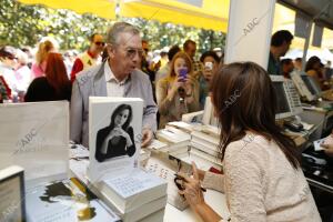 María Dueñas firmando sus obras mientras el público se arremolinaba y le hacía...