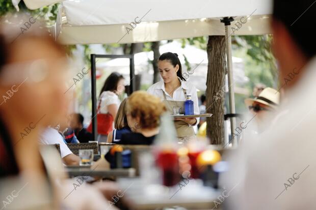 En la imagen, un camarero atiende a una de las mesas de turistas en una terraza...