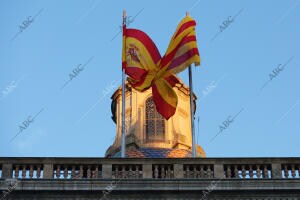 Las banderas de España y Cataluña se cruzan debido al viento en el Palau de la...