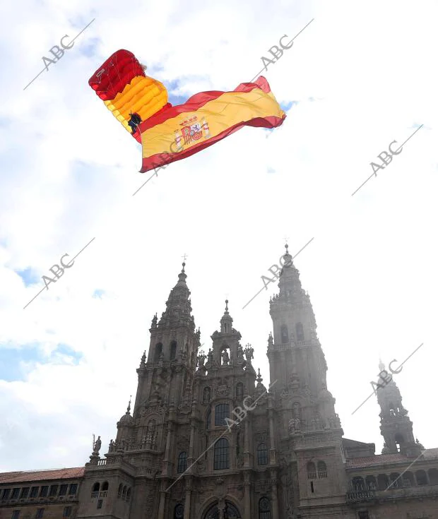 En la imagen, un paracaidista cruza plaza del Obradoiro con la bandera de España