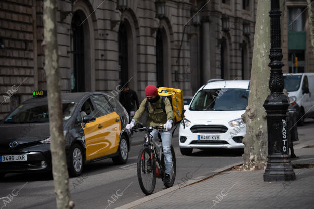 En la imagen, un taxi y un repartidor de Glovo