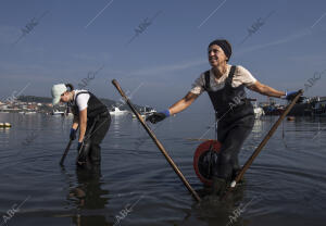 Dos mariscadoras faenando en la playa de La Sapeira