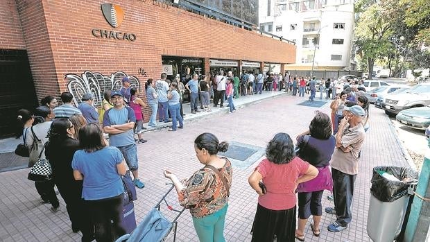Un grupo de venezolanos hace cola para comprar medicinas en una farmacia de Caracas