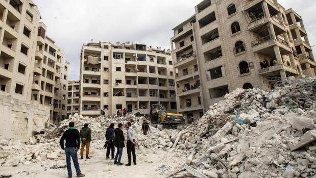 Varias personas observan la búsqueda de supervivientes por parte de voluntarios de Defensa Civil Siria, tras un ataque aéreo ruso sobre Idlib, el pasado 5 de febrero