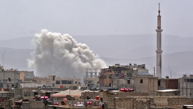 Columna de humo en el sur de la capital siria, Damasco, dende las fuerzas de Al Assad han bombardeado un enclave en manos de los rebeldes