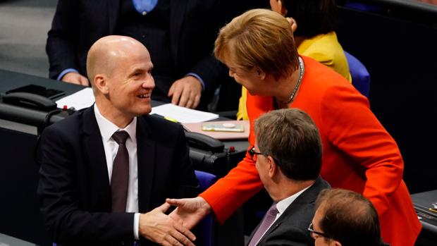 La canciller alemana, Angela Merkel (d), saluda al recién elegido jefe del grupo parlamentario conservador CDU/CSU, Ralph Brinkhaus (i)