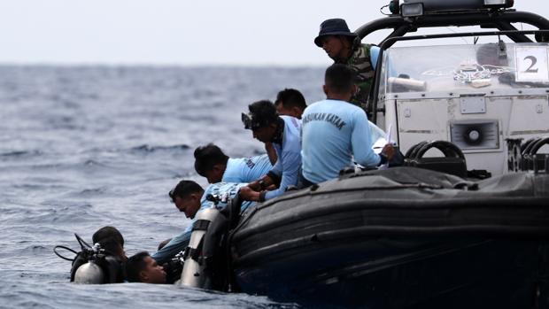 Miembros de los servicios de rescate trabajan en la recuperación de los restos del avión accidentado en el mar de Java cerca de la costa indonesia