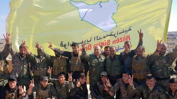 Combatientes de las Fuerzas Democráticas Sirias (FDS) hacen el signo de la victoria tras la caída de Baghouz
