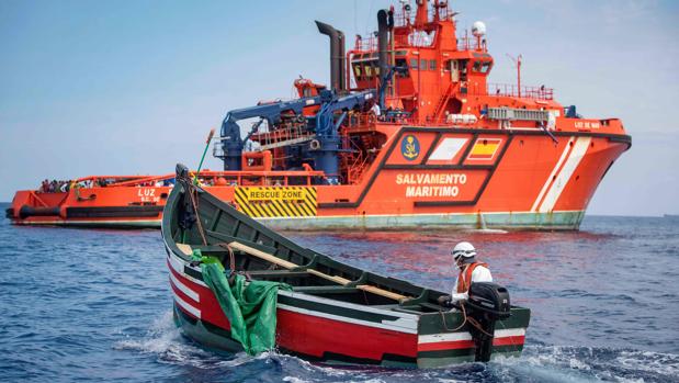 Un miembro de la agencia de búsqueda y rescate marítimo Salvamento Marítimo regresa a su embarcación a bordo de un bote utilizado por migrantes varados en el Estrecho de Gibraltar al final de una operación de rescate con la Guardia Civil Española