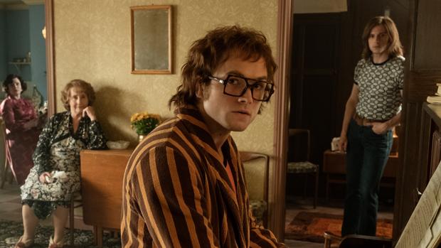 Elton John (Taron Egerton), interpreta una canción al piano, en su casa, antes de ser la estrella mundial del pop