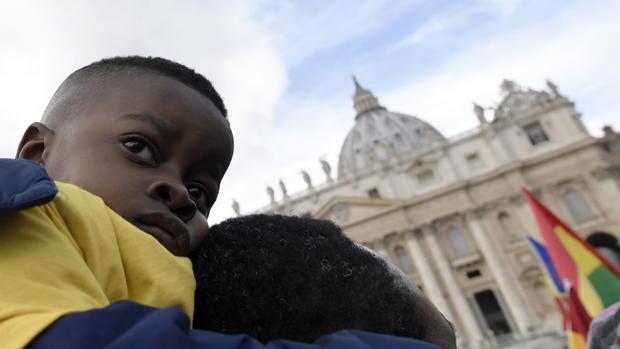 Un niño escucha el rezo del Ángelus en la plaza de San Pedro