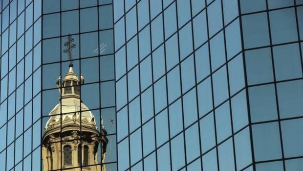 ista de una de la cúpulas de la catedral de Santiago reflejada en un edificio