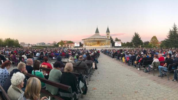 Peregrinos rezan frente a la Parroquia de Santiago Apostol en Medjugorje