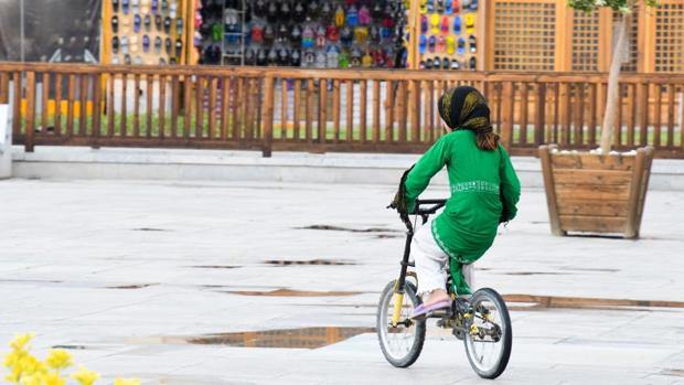 Niña en bicicleta con velo en Irán