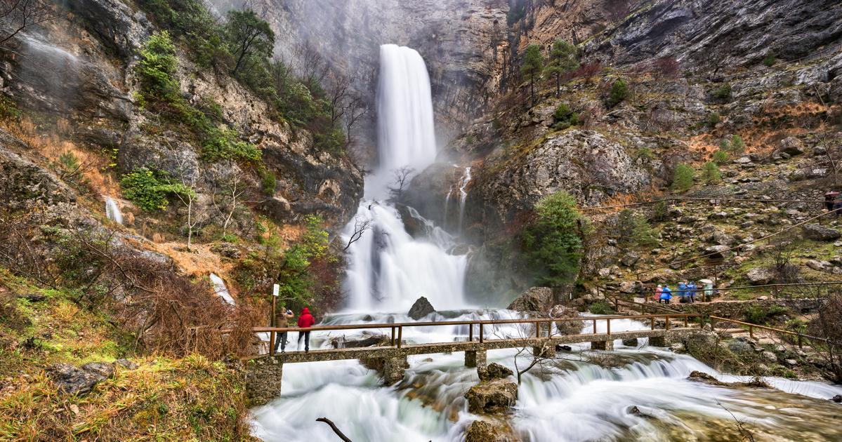 An aerial view of waves crashing against a shore.